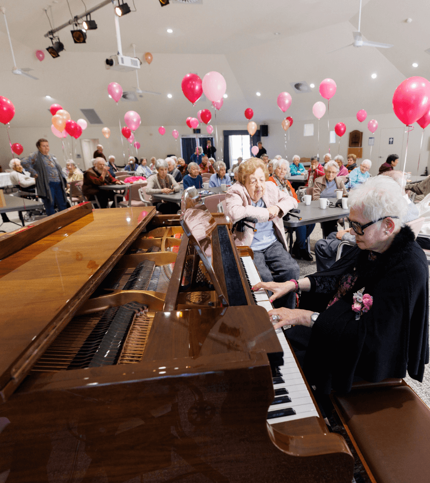 Gabrielle playing piano to Alan Walker Village residents