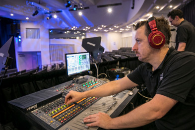 Man from Wesley Mission audio-visual team operating audio-visual equipment at Wesley Conference Centre,