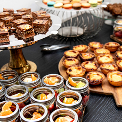 Assortment of food from Wesley Conference Centre catering including fruit cups, brownies, and portugese tarts,