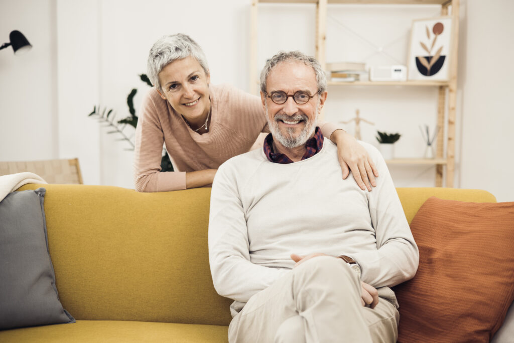 Portrait of happy senior husband and wife relaxing at home
