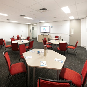Medium side view shot of Pendlebury Room at the Wesley Conference Centre, with Wesley Mission logo showing on digital screen