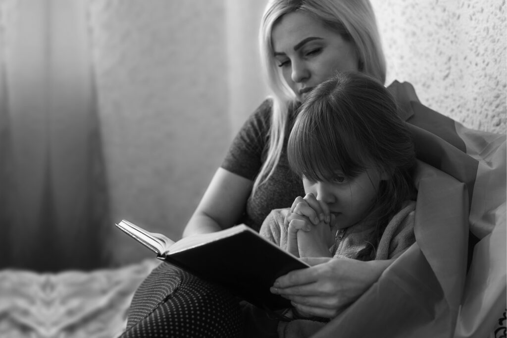 Woman and child reading book together
